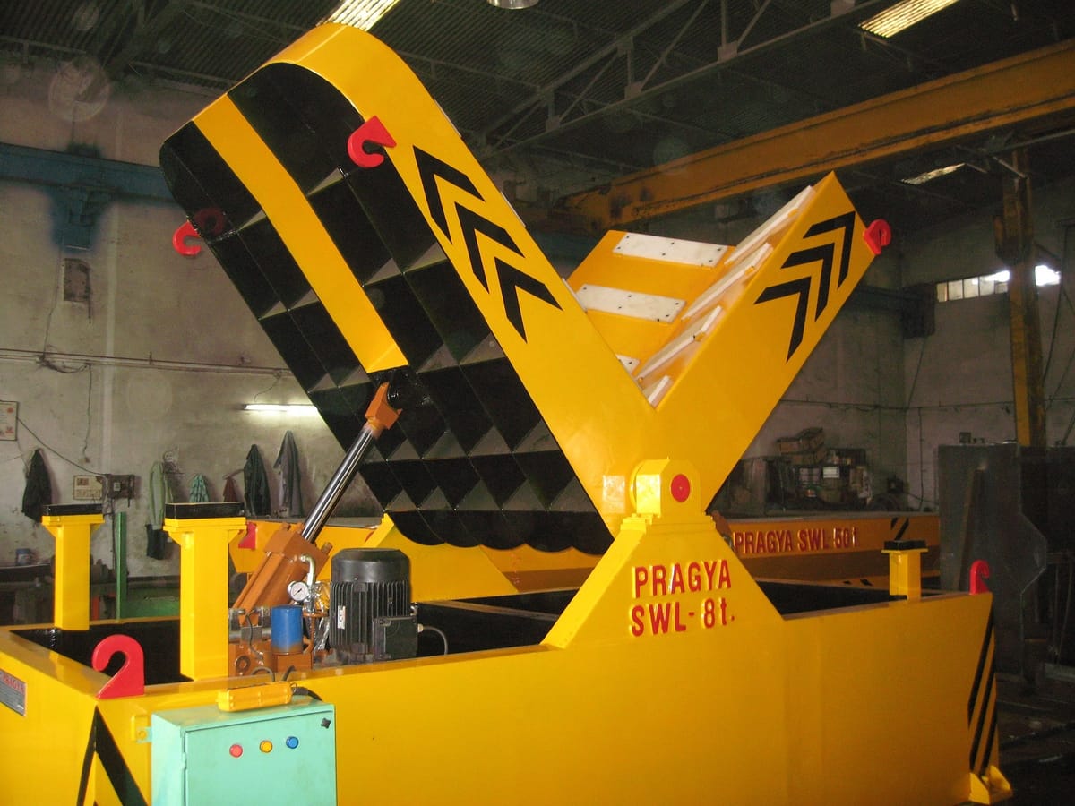 Hydraulic coil tilter mid-rotation, showing the low-profile base and coil cradle